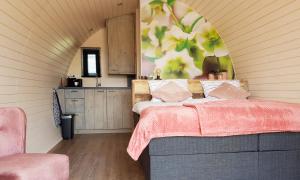 - une chambre avec un lit et une couverture rose dans l'établissement GreenFloat Boskoop - #1, à Boskoop