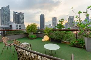 a balcony with a table and chairs and a city skyline at Volve Hotel Bangkok in Bangkok