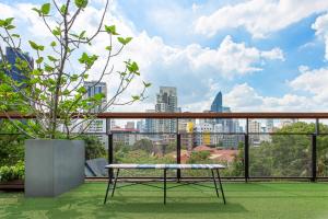 a bench on a balcony with a view of the city at Volve Hotel Bangkok in Bangkok