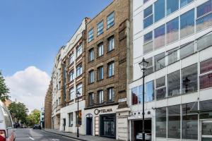 a brick building on a city street at Mulberry South Penthouse by City Living London in London