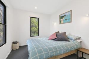 Un dormitorio con una cama y dos ventanas. en Trouvaille At Wye, en Wye River