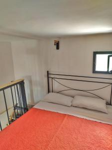 ein Schlafzimmer mit einem Bett mit einer orangefarbenen Decke in der Unterkunft Ingrosso house Mini loft Lecce in Lecce