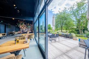 a patio with glass doors and tables and chairs at GreenFloat Boskoop - #1 in Boskoop