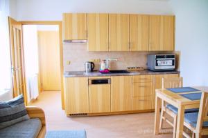 a small kitchen with wooden cabinets and a table at Aviatik apartmány in Jeseník