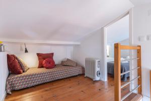 een woonkamer met een bank en een bed bij Alfama 2BDR Duplex Apartment W/ Balcony by LovelyStay in Lissabon