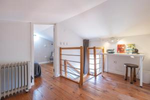 een woonkamer met een houten vloer en een tafel bij Alfama 2BDR Duplex Apartment W/ Balcony by LovelyStay in Lissabon