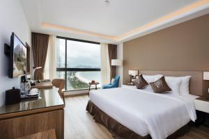 Postel nebo postele na pokoji v ubytování Comodo Nha Trang Hotel
