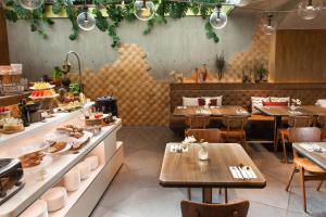 a restaurant with tables and chairs and a buffet at Volve Hotel Bangkok in Bangkok