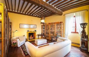 Agriturismo Mansi Bernardini في لوكّا: غرفة معيشة مع كنبتين بيضاء ومدفأة