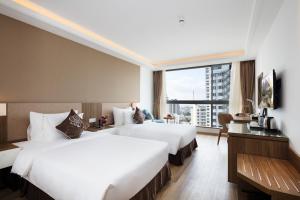 Postel nebo postele na pokoji v ubytování Comodo Nha Trang Hotel
