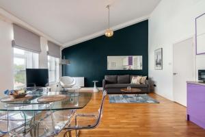 uma sala de estar com uma mesa de vidro e um sofá em Mulberry North Penthouse by City Living London em Londres