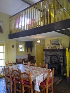 a dining room with a table and chairs and a staircase at Drumaneir Cottage in Carrickmore