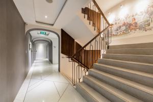 a hallway with stairs with a painting on the wall at Volve Hotel Bangkok in Bangkok