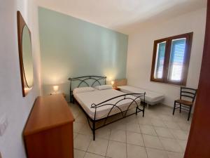 フォッローニカにあるappartamento Via Siena 1のベッドルーム1室(ベッド1台、テーブル、窓2つ付)