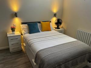 um quarto com uma cama grande e almofadas coloridas em Pods of Kings Cross -1 em Londres