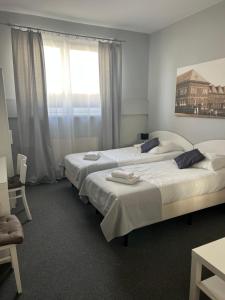 ein Schlafzimmer mit drei Betten und einem Fenster in der Unterkunft Hotel Turkovia in Turek