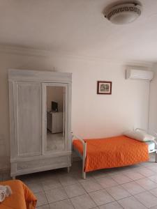 een slaapkamer met een oranje bed en een kast bij B&B Al Dammuso in Agrigento