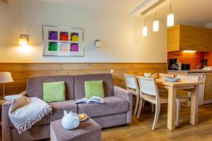 a living room with a couch and a table at Résidence Pierre & Vacances Les Gémeaux in Belle Plagne