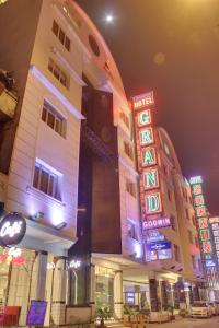 a group of buildings with neon signs at night at Hotel Grand Godwin - Near New Delhi Railway Station - Paharganj in New Delhi