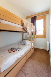 a bedroom with two bunk beds and a window at Résidence Pierre & Vacances Les Gémeaux in Belle Plagne