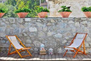 
a wooden bench sitting in front of a stone wall at Vasilikis House in Kalopanayiotis
