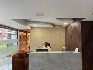 een man aan een bureau met een laptop bij Hotel Joyce in Chennai