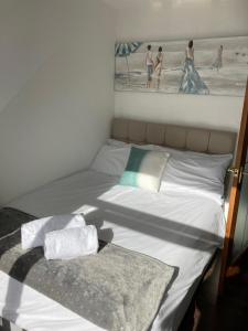 a bed in a bedroom with a picture on the wall at 2 Bedroom apartment, with free parking in Largs