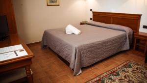 1 dormitorio con cama, mesa y escritorio en Bagno Santo Residence en Saturnia