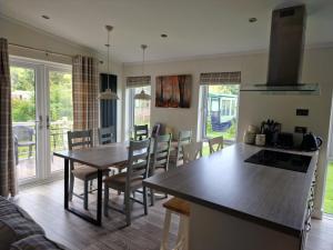 a kitchen and dining room with a table and chairs at Maple 2 Bedroom Luxury Lodge in Mid Wales in Welshpool