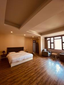 um quarto grande com uma cama grande e pisos em madeira em THE APARTMENT em Gangtok