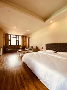 1 dormitorio con 1 cama blanca grande y 1 sofá en THE APARTMENT, en Gangtok