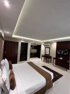 ein Schlafzimmer mit einem großen Bett und ein Wohnzimmer in der Unterkunft Al Muhaidb Al Taif Hotel in Al Hada