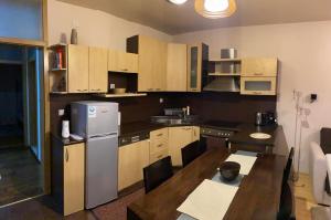 a small kitchen with a table and a refrigerator at Redon's City Center Apartment in Prishtinë