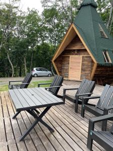 eine Holzterrasse mit 3 Stühlen und einer Kabine in der Unterkunft North Villge Hirugano - Vacation STAY 21286v in Gujō