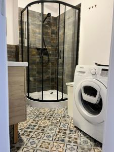 een badkamer met douche en wasmachine bij Central Apartment in Bydgoszcz