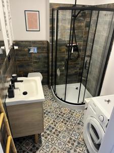 a bathroom with a shower and a sink and a toilet at Plac Poznański Apartament in Bydgoszcz