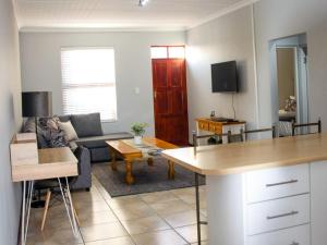 uma sala de estar com um sofá e uma mesa em De Hoek Selfsorg Eenhede em Beaufort West