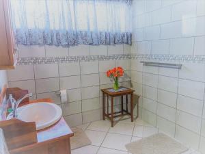 a bathroom with a sink and a vase of flowers on a table at Six Second Avenue in Parys