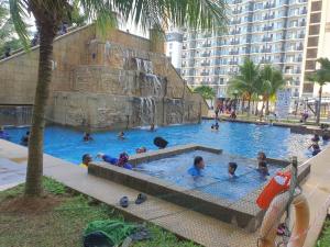 un grupo de niños jugando en una piscina en Swiss Garden Resort Residence, studio, sea & pool view, high level unit, en Kuantan