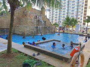 a group of children playing in a swimming pool at Swiss Garden Resort Residence, studio, sea & pool view, high level unit in Kuantan