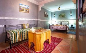 a bedroom with a bed and a table in a room at RIAD BIEN ICI in Marrakesh