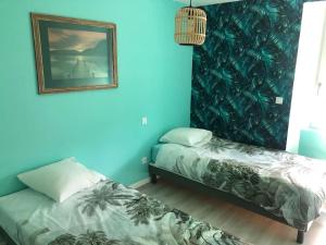 two beds in a room with blue walls at Gîte Loue in Ornans +45 photos