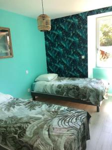 ein Schlafzimmer mit 2 Betten und einer blauen Wand in der Unterkunft Gîte Loue in Ornans