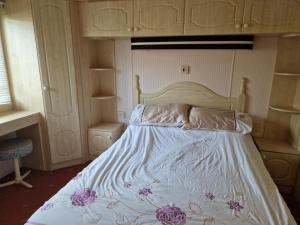 a bedroom with a bed with purple flowers on it at Willerby Shrewsbury - Pitch 51 in Welshpool