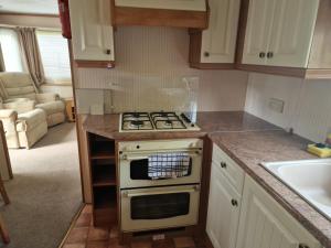 a kitchen with a stove and a sink at Willerby Shrewsbury - Pitch 51 in Welshpool