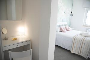 a bedroom with a bed and a desk with a mirror at Perla Vacanza in Santa Marinella