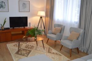 a living room with two chairs and a television at Villa Reis Sao Goncalo in Funchal