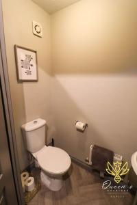 a bathroom with a white toilet in a room at Cheerful Queens Quarters Boutique Rooms in Hartford