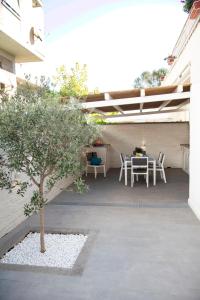a patio with a table and chairs and a tree at Perla Vacanza in Santa Marinella
