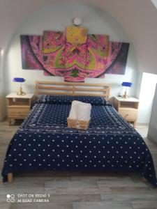 - une chambre avec un lit et une couette bleue dans l'établissement Mandala Le Gardien, à Palagiano